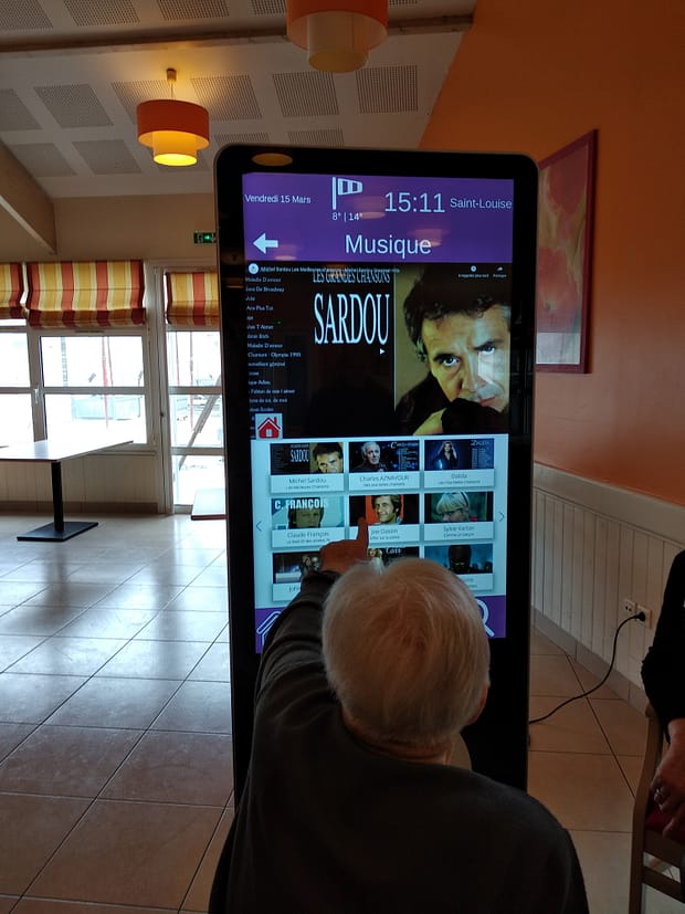 Borne interactive dans une EHPAD permettant d'écouter de la musique comme Michel Sardou ou Charles Aznavour